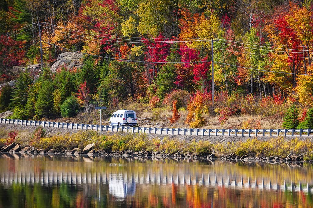 Van traveling down the road with fall foliage