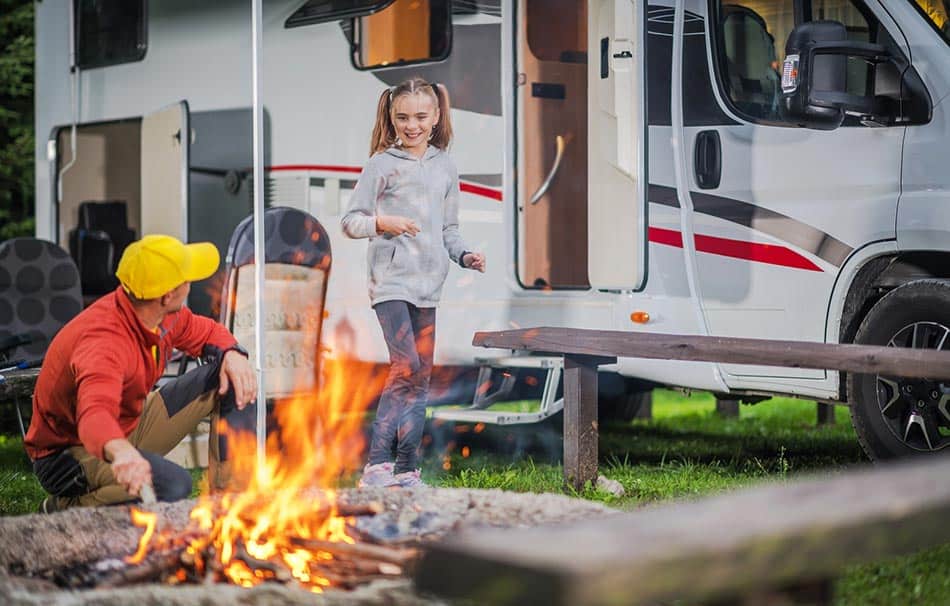 Father and daughter camping by the campfire