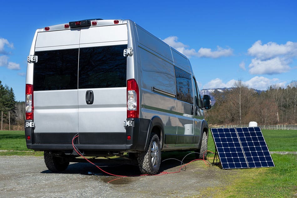Camper van with solar panels sitting on ground