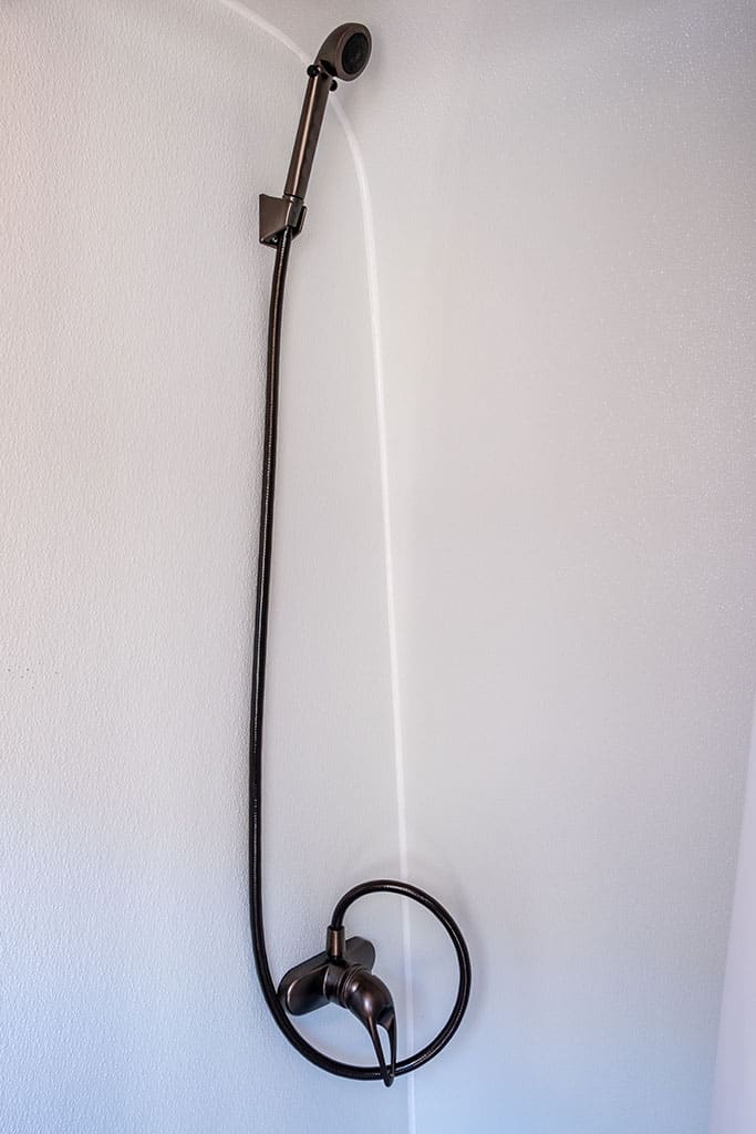 Shower wand hanging on wall