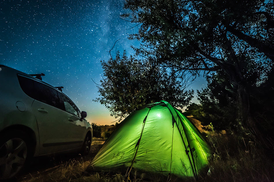 Camping in a tent beside car