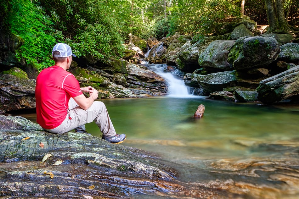 Dan Collins sitting by waterfall in Blue Ridge Mountains