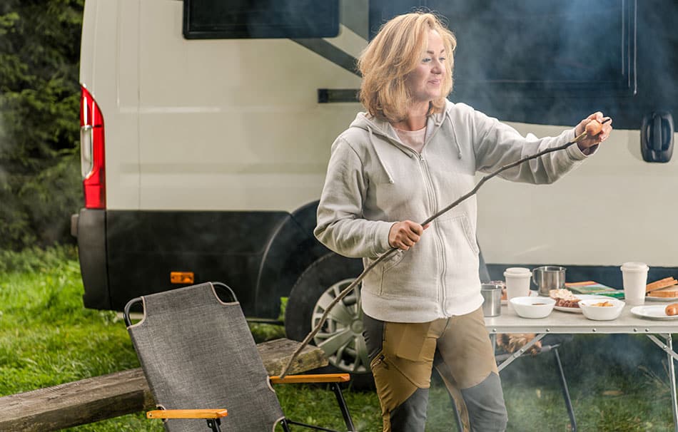 Woman enjoying cooking while camping